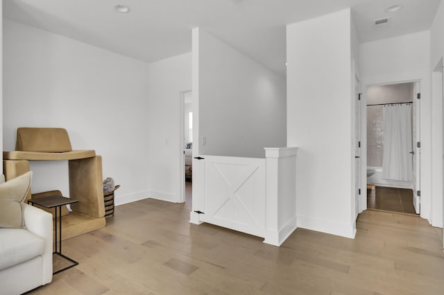 living area with recessed lighting, visible vents, baseboards, and wood finished floors