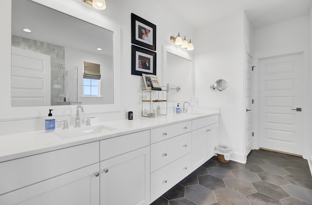 full bath with a sink, a stall shower, double vanity, and tile patterned flooring