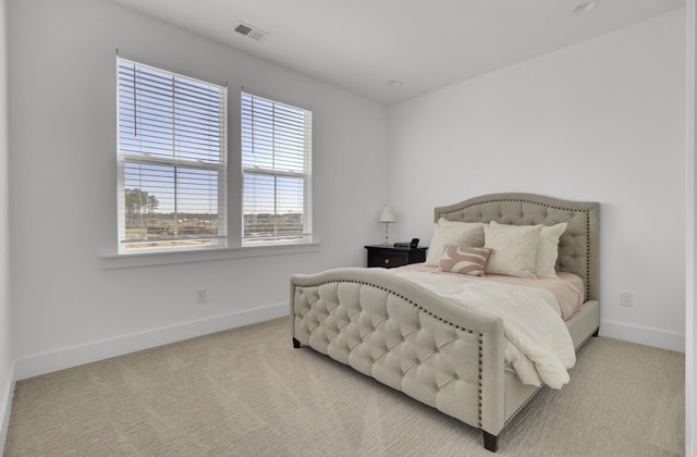 carpeted bedroom with visible vents and baseboards