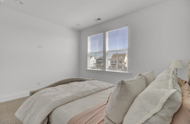 bedroom with baseboards, carpet floors, and visible vents