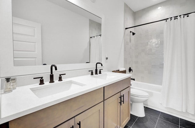 bathroom featuring a sink, shower / bath combo with shower curtain, toilet, and double vanity