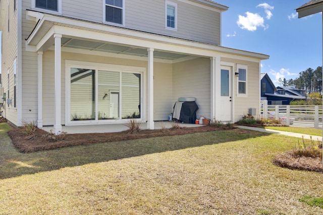 back of property with a lawn, a patio, and fence