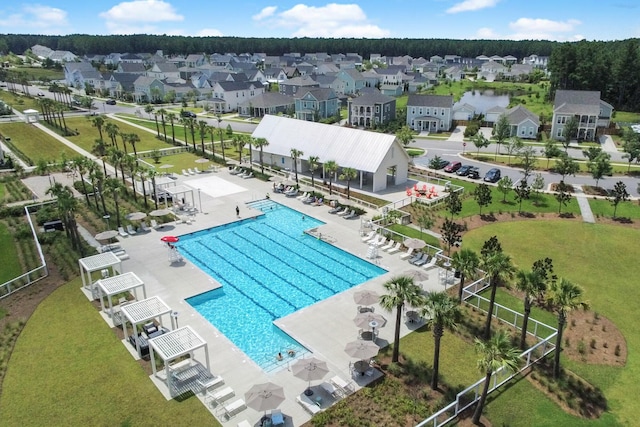 community pool featuring a residential view, a patio, and fence