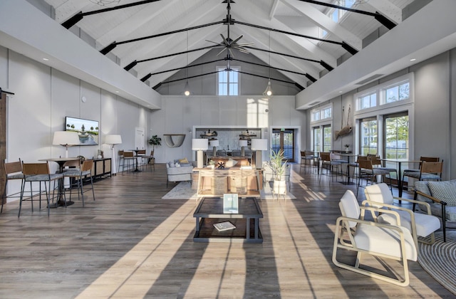 living area featuring beamed ceiling, high vaulted ceiling, and wood finished floors