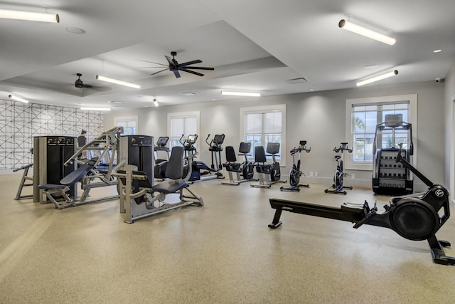 gym with baseboards and ceiling fan