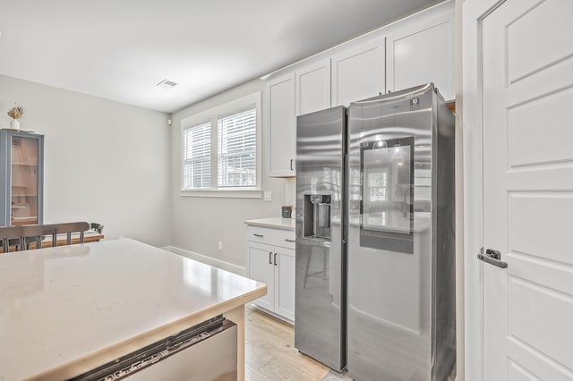 kitchen with appliances with stainless steel finishes, light hardwood / wood-style floors, and white cabinetry