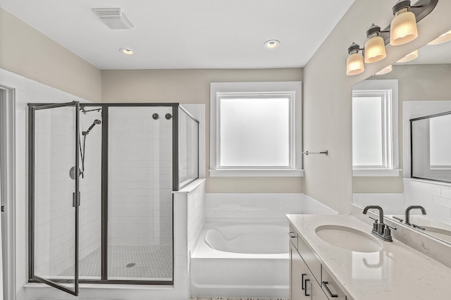 bathroom with vanity, a wealth of natural light, and plus walk in shower