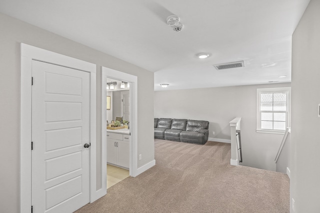 hallway featuring light colored carpet