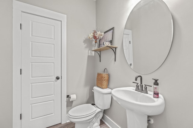 bathroom featuring toilet, sink, and hardwood / wood-style floors