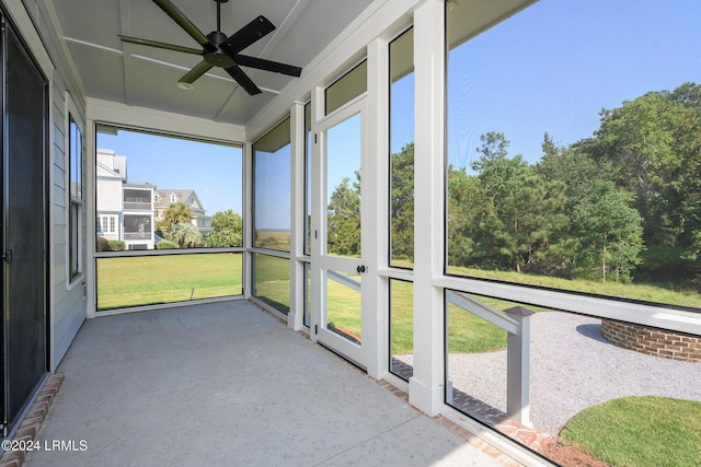 unfurnished sunroom featuring ceiling fan