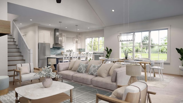 living room featuring a healthy amount of sunlight, light hardwood / wood-style flooring, and high vaulted ceiling