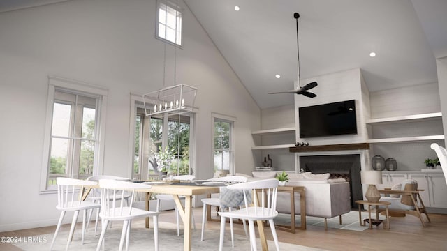 dining area featuring a high ceiling, plenty of natural light, light wood-type flooring, and a fireplace