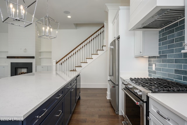 kitchen featuring premium range hood, white cabinetry, stainless steel appliances, decorative light fixtures, and dark hardwood / wood-style flooring