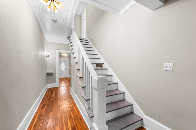 staircase featuring hardwood / wood-style flooring and ornamental molding