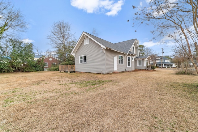 view of side of property featuring a yard and a deck