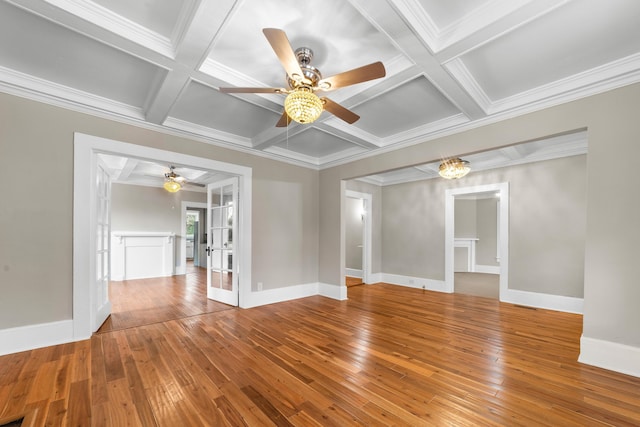 empty room with beamed ceiling, hardwood / wood-style flooring, coffered ceiling, and french doors