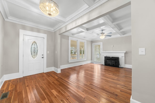 entrance foyer featuring hardwood / wood-style flooring, beam ceiling, coffered ceiling, a fireplace, and ornamental molding