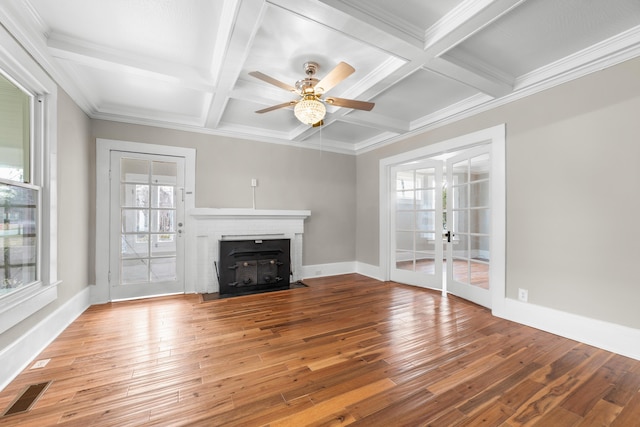 unfurnished living room with beamed ceiling, plenty of natural light, and coffered ceiling