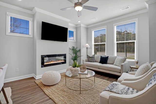 living room with crown molding, dark wood-type flooring, and ceiling fan