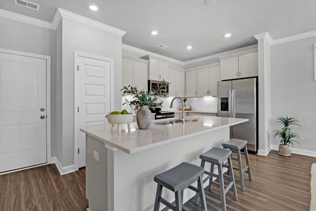 kitchen featuring dark wood-type flooring, stainless steel fridge, and a kitchen island with sink