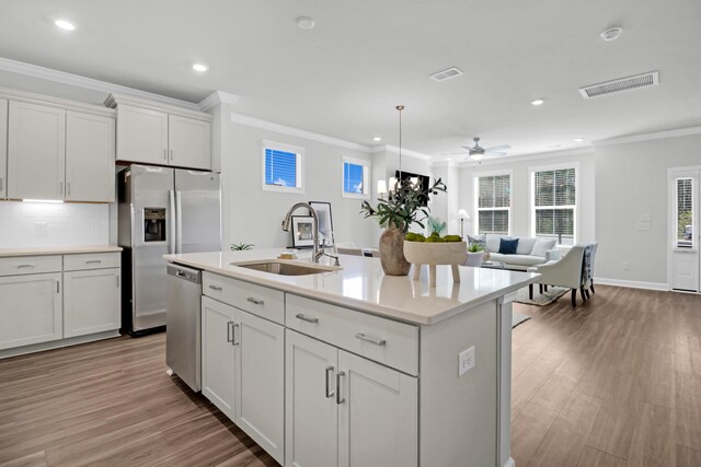 kitchen featuring light hardwood / wood-style flooring, sink, ceiling fan, and an island with sink