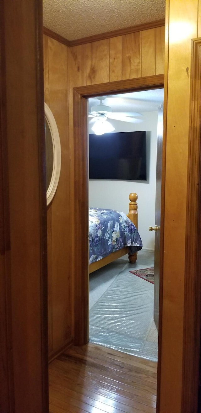 107 Kelly St, Walterboro, SC 29488 - doorway to outside featuring a ceiling fan, a textured ceiling, wood-type flooring, wooden walls, and crown molding