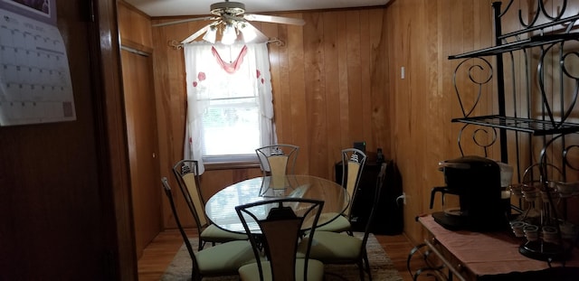 107 Kelly St, Walterboro, SC 29488 - dining space with wooden walls, a ceiling fan, and light wood-style floors