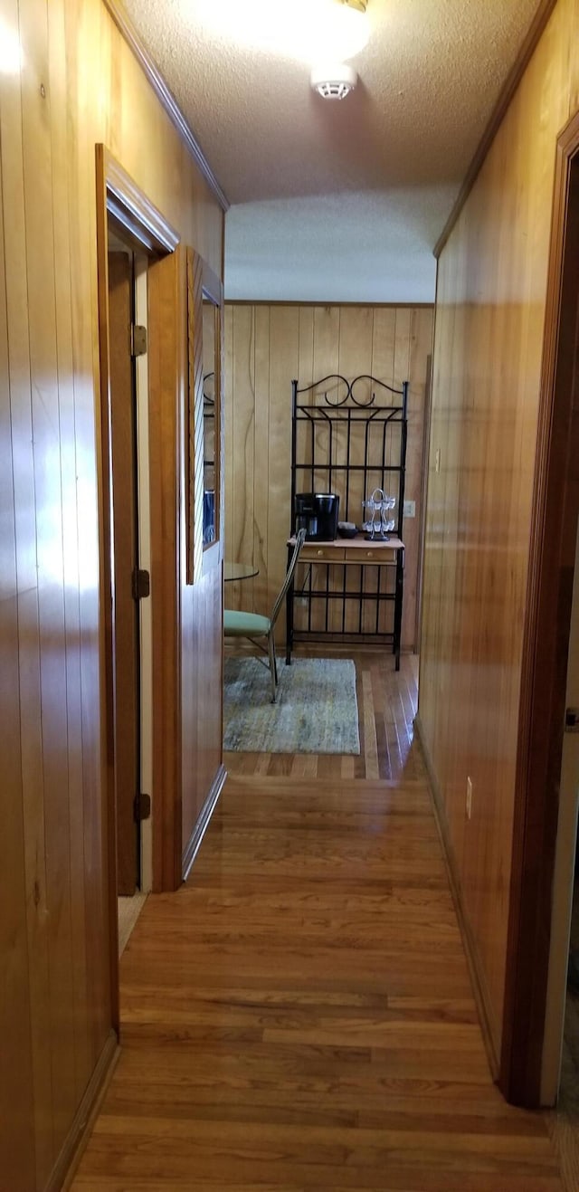 107 Kelly St, Walterboro, SC 29488 - hallway featuring a textured ceiling, wooden walls, wood finished floors, and ornamental molding