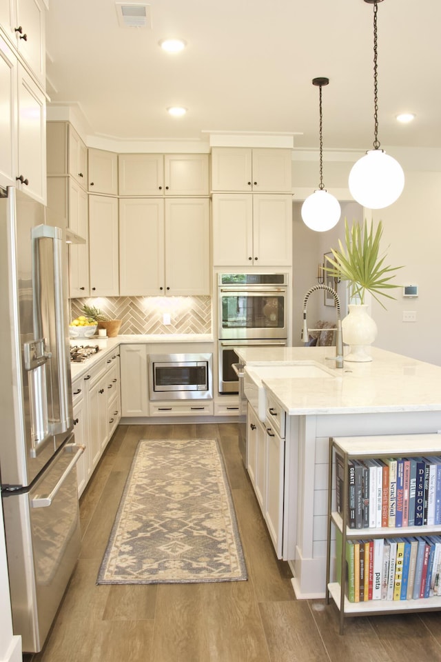 1723 Bolden Dr, Mount Pleasant, SC 29466 - kitchen featuring appliances with stainless steel finishes, light countertops, an island with sink, hanging light fixtures, and recessed lighting