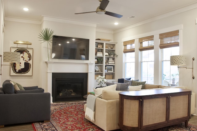 1723 Bolden Dr, Mount Pleasant, SC 29466 - living room with a ceiling fan, crown molding, a glass covered fireplace, wood finished floors, and built in shelves