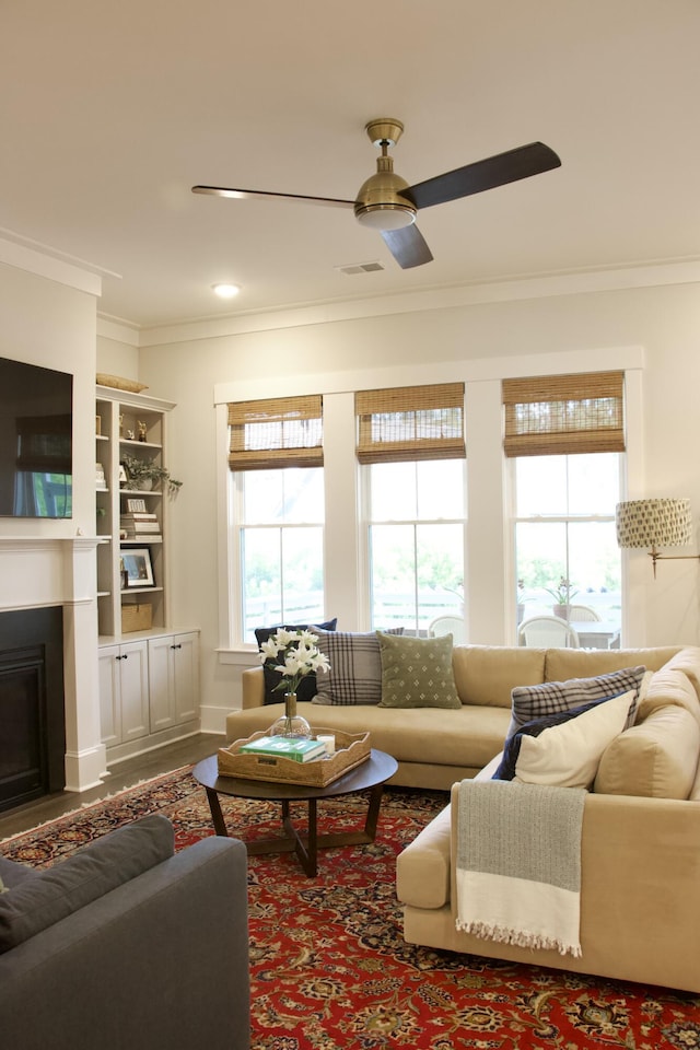 1723 Bolden Dr, Mount Pleasant, SC 29466 - living room featuring healthy amount of natural light, ornamental molding, ceiling fan, and a fireplace with flush hearth
