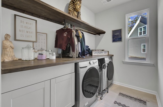 washroom featuring visible vents, baseboards, washing machine and dryer, laundry area, and light wood-style floors