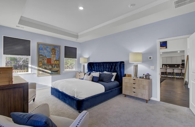 carpeted bedroom featuring visible vents, recessed lighting, baseboards, and a tray ceiling