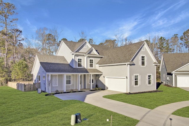 traditional-style home with driveway, a shingled roof, a front yard, and fence