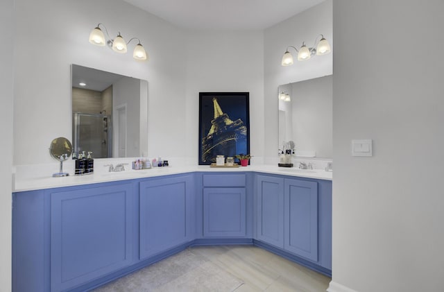 bathroom featuring a sink, double vanity, and a shower stall