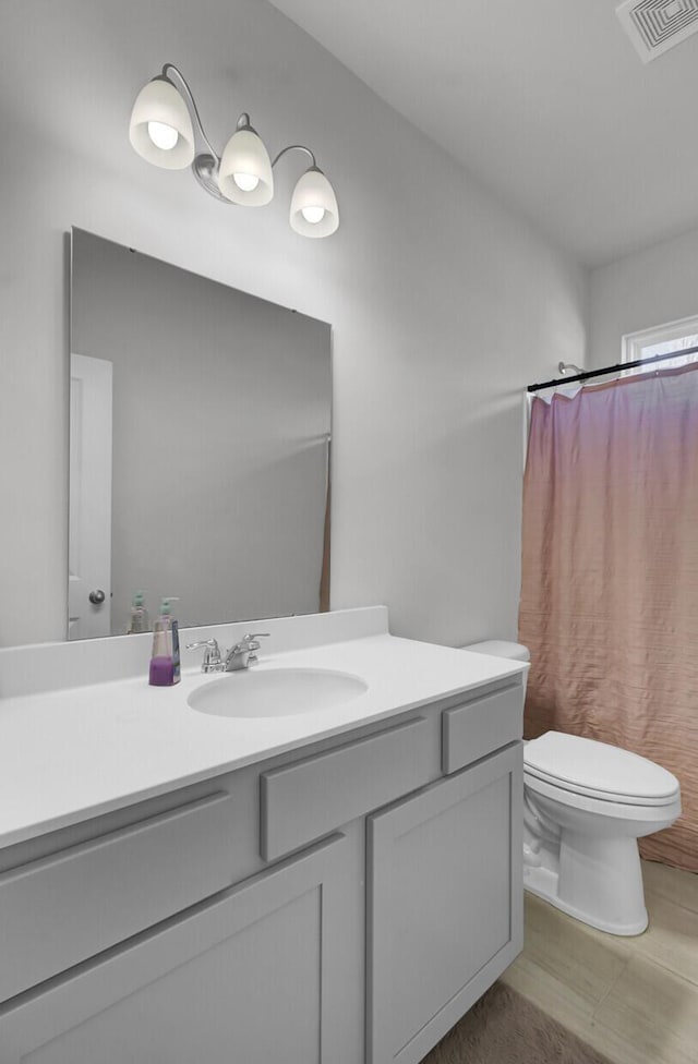 full bathroom featuring vanity, toilet, a shower with curtain, and visible vents