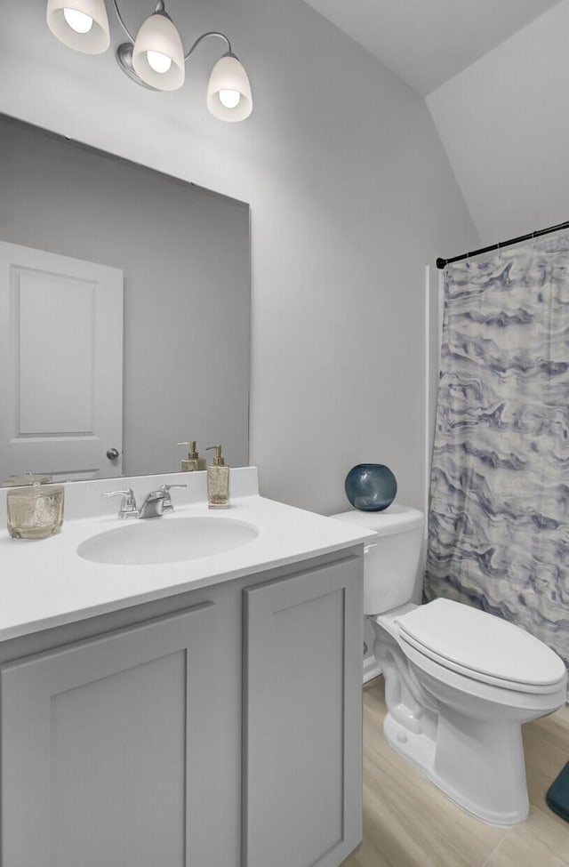 bathroom with vanity, vaulted ceiling, toilet, and a shower with shower curtain