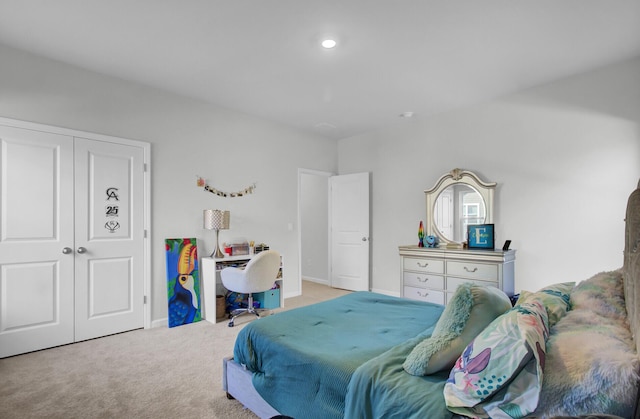 bedroom with a closet, light carpet, and baseboards