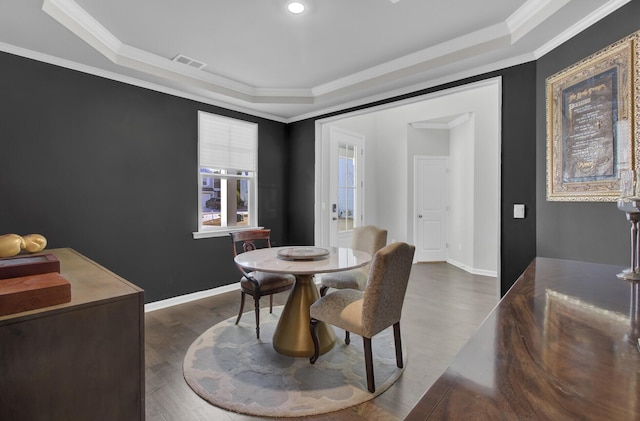 dining room featuring a raised ceiling, crown molding, and visible vents