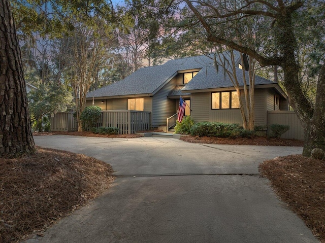 view of front facade featuring concrete driveway and fence