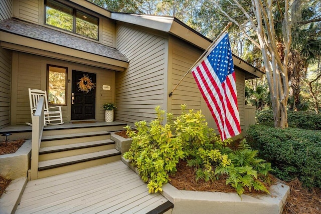 entrance to property featuring a shingled roof