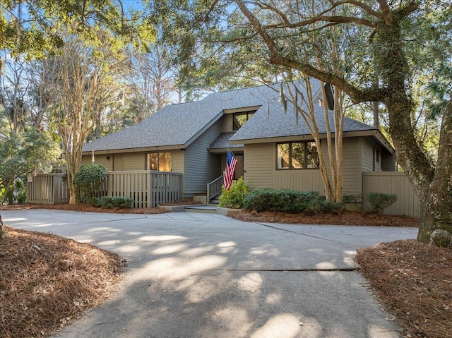 view of front of property featuring fence and roof with shingles