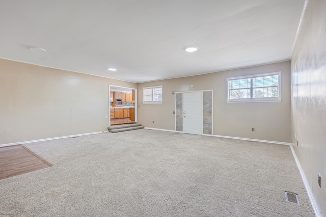 unfurnished living room featuring carpet