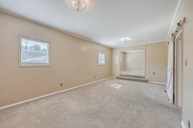 unfurnished bedroom featuring a barn door, crown molding, and light colored carpet