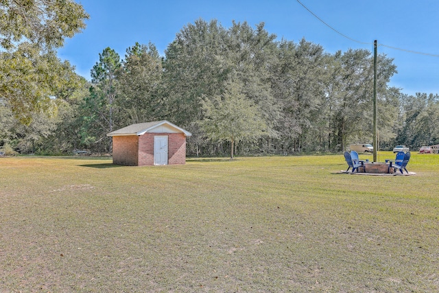 view of yard with a storage shed and an outdoor fire pit