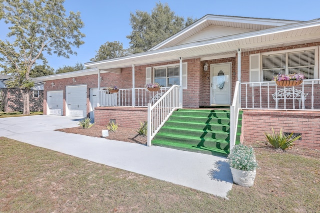 view of front of property featuring a front yard, a garage, and covered porch