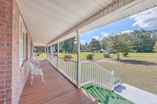 wooden deck featuring a yard and a porch