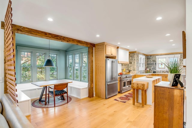 kitchen featuring a center island, breakfast area, light wood-style floors, appliances with stainless steel finishes, and light countertops