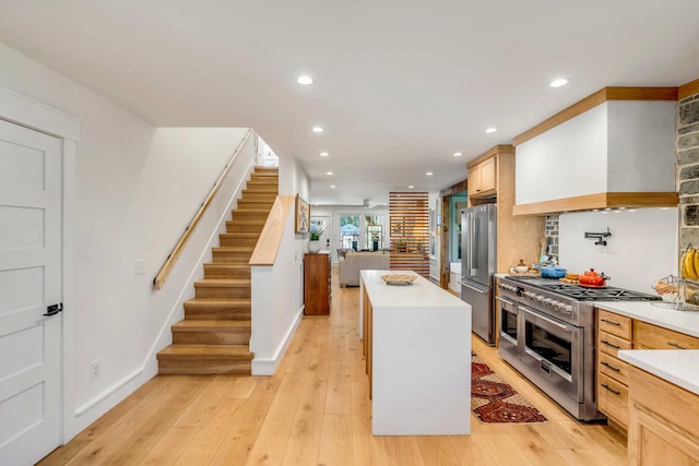 kitchen with light wood-style floors, premium appliances, premium range hood, and a center island