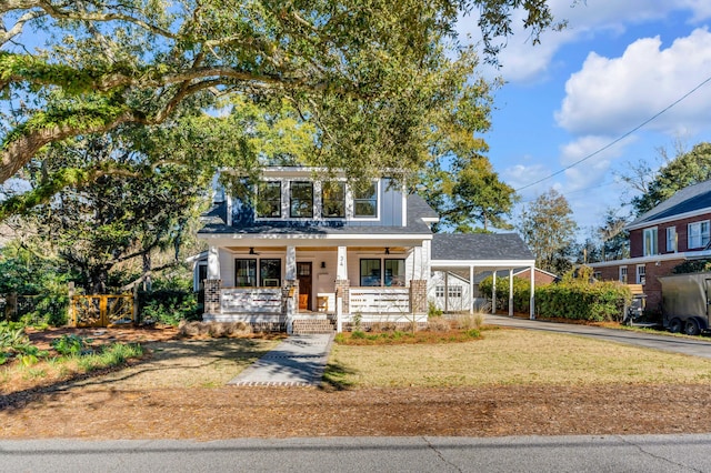 view of front facade with an attached carport, driveway, covered porch, and a front yard